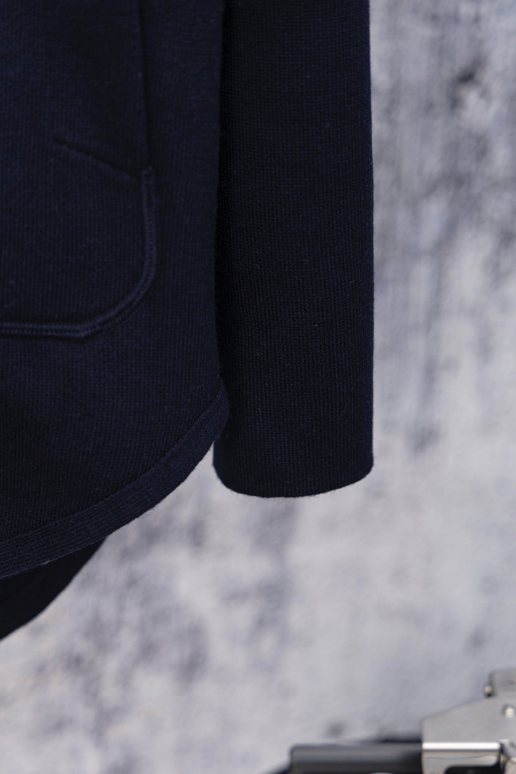 Navy hoodie sleeve and hem detail, side seam close-up