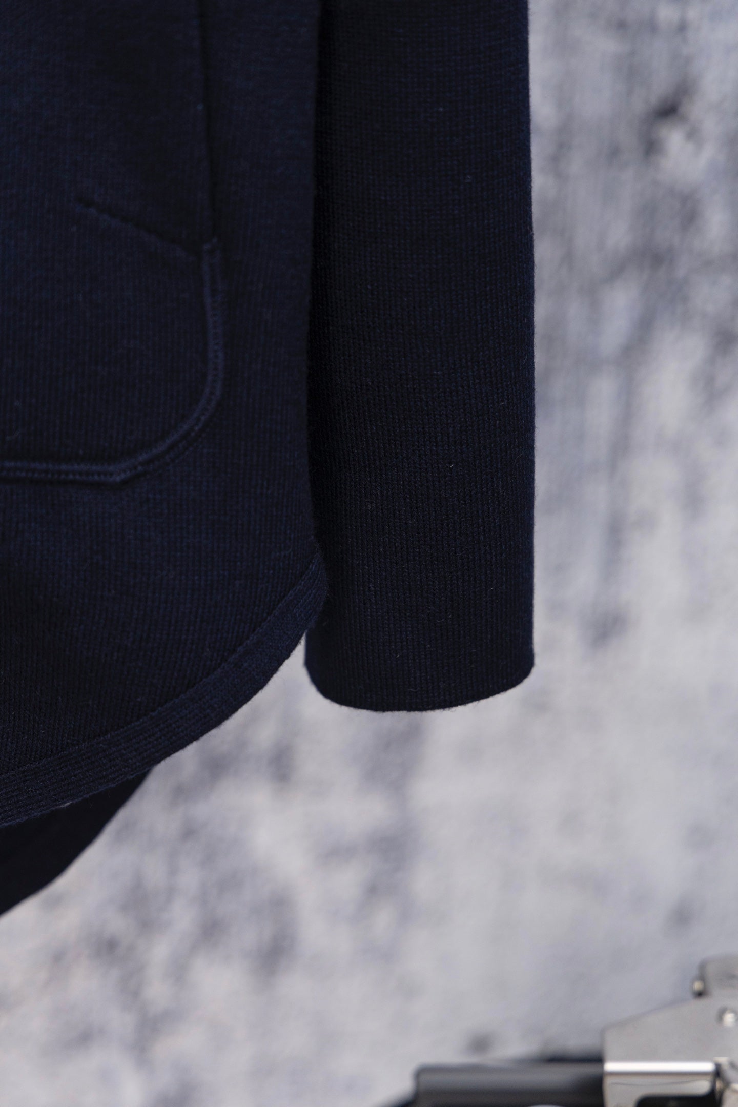 Navy hoodie sleeve and hem detail, side seam close-up