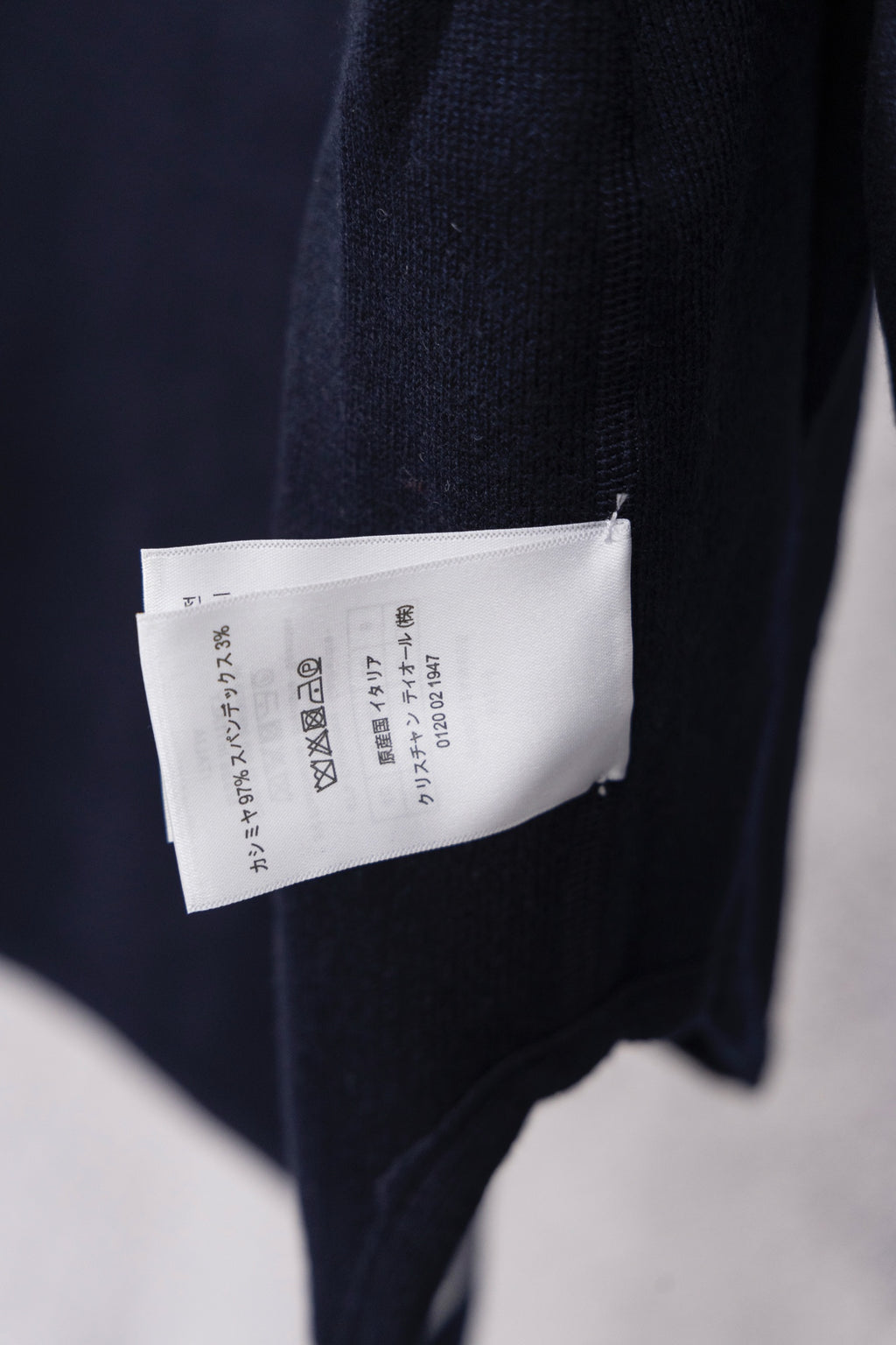 Dior hooded top showing back care label tag on navy fabric