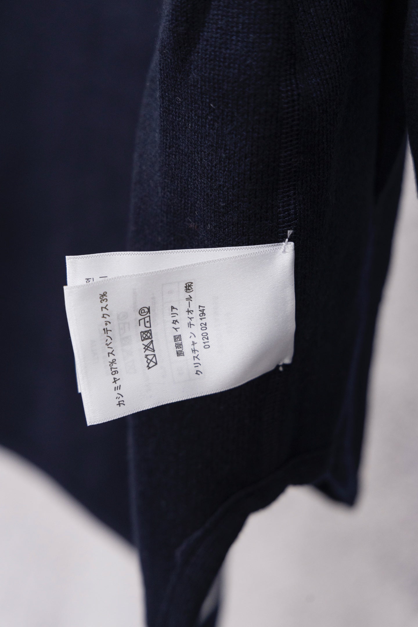 Dior hooded top showing back care label tag on navy fabric
