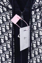 Dior hooded top with navy zipper, monogram print, and white retail tags