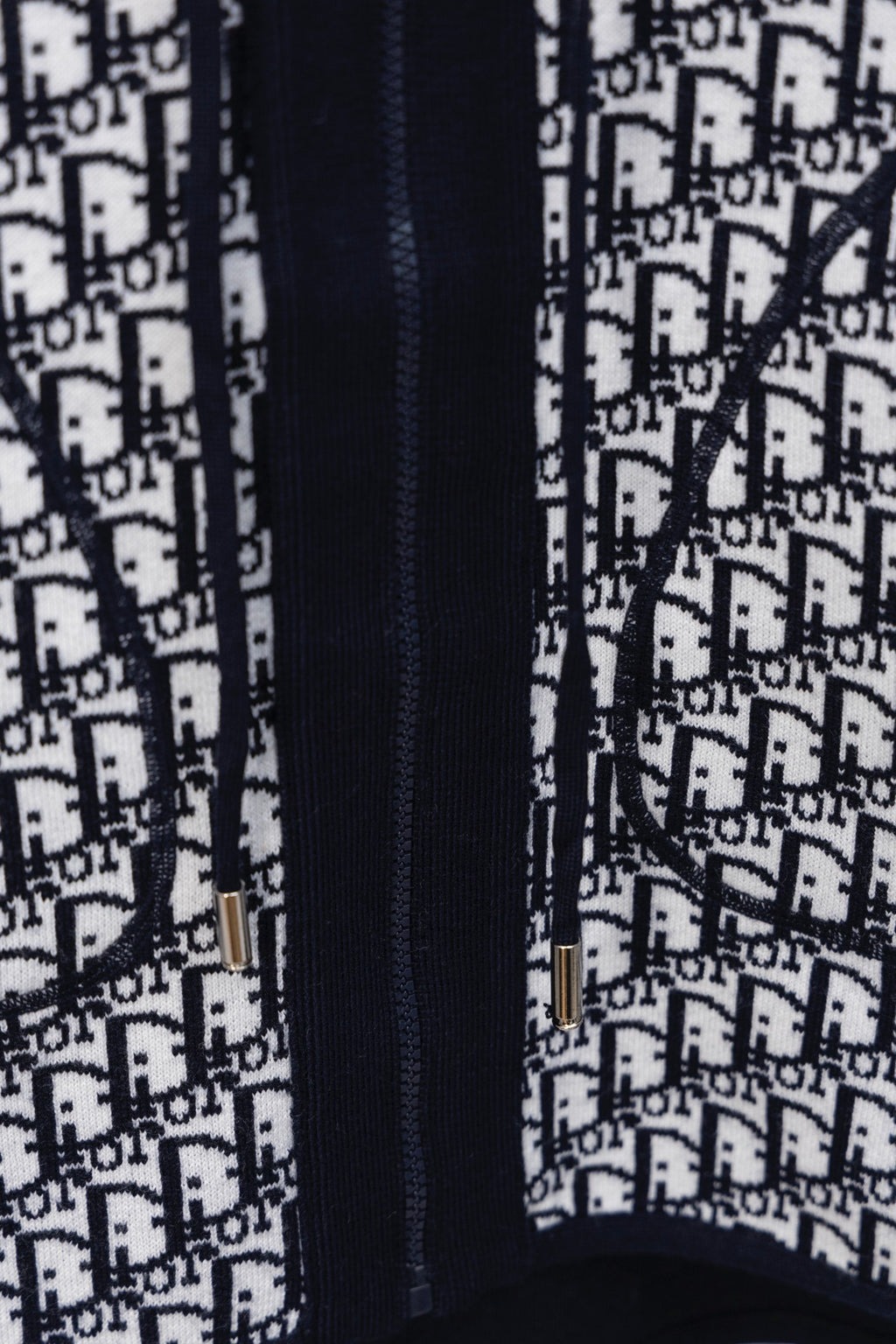 Dior hooded top close-up of navy zip and white Dior monogram pattern