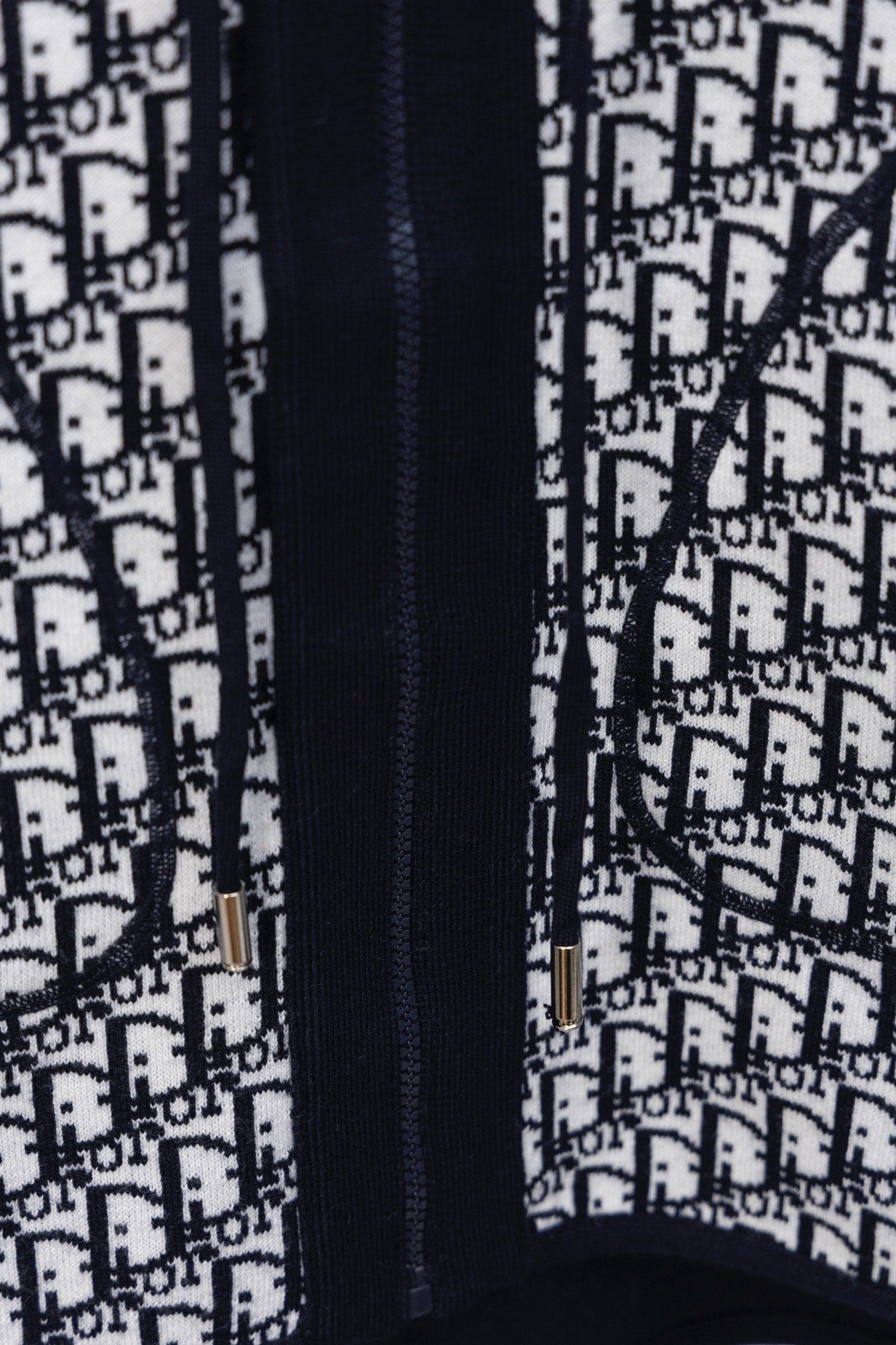 Dior hooded top close-up of navy zip and white Dior monogram pattern