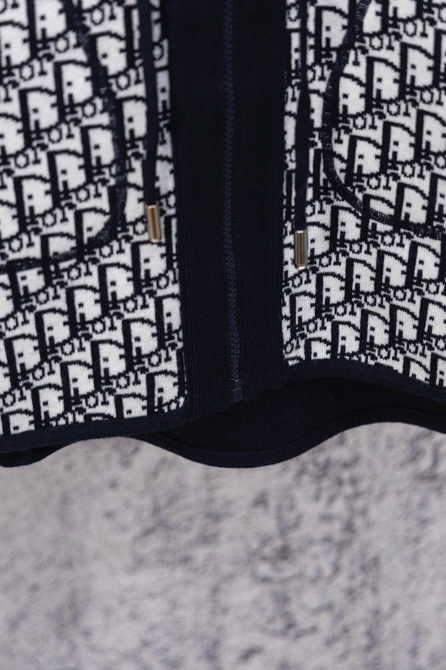 Dior patterned hooded top with navy zipper placket and contrast panel