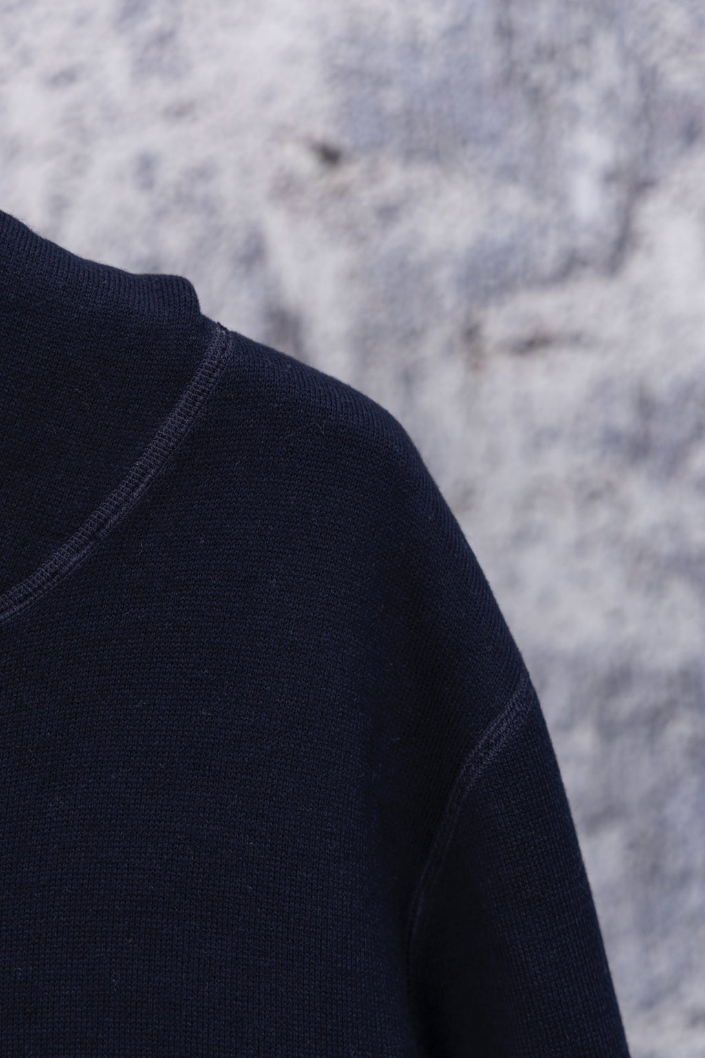 Navy hoodie shoulder and sleeve close-up, smooth knit texture