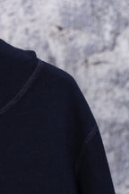Navy hoodie shoulder and sleeve close-up, smooth knit texture