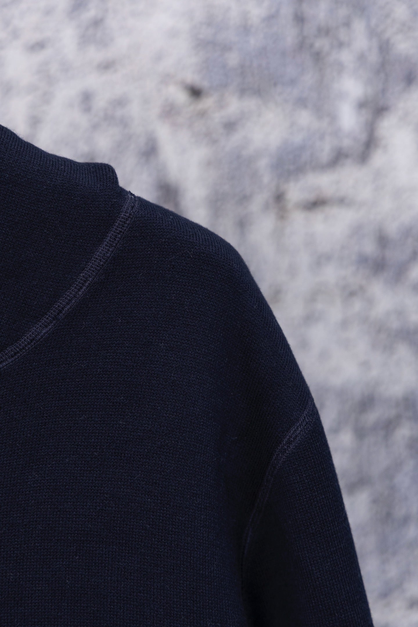 Navy hoodie shoulder and sleeve close-up, smooth knit texture