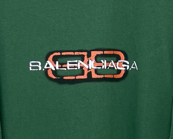 Close-up of Balenciaga logo print on green T-shirt