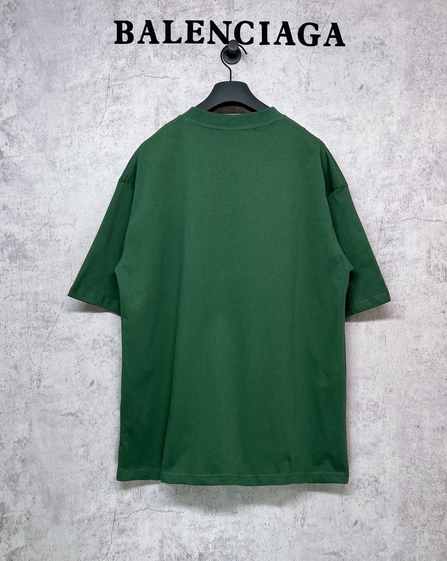 Green T-shirt back view on hanger, short sleeves