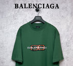 Green T-shirt with orange and white Balenciaga logo print on chest