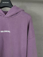 Purple long hoodie with long sleeves and partial BALENCIAGA logo on chest.