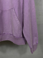 Purple long hoodie showing sleeve and kangaroo pocket seams at lower hem.