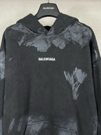 Balenciaga pullover hoodie with hood, distressed paint-like print, small centered logo text