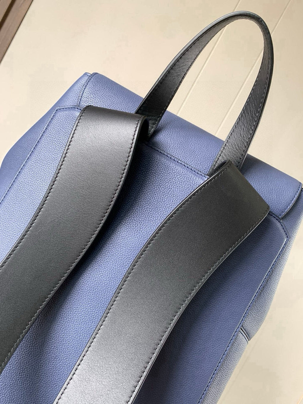 Blue leather backpack with contrast gray shoulder strap panels
