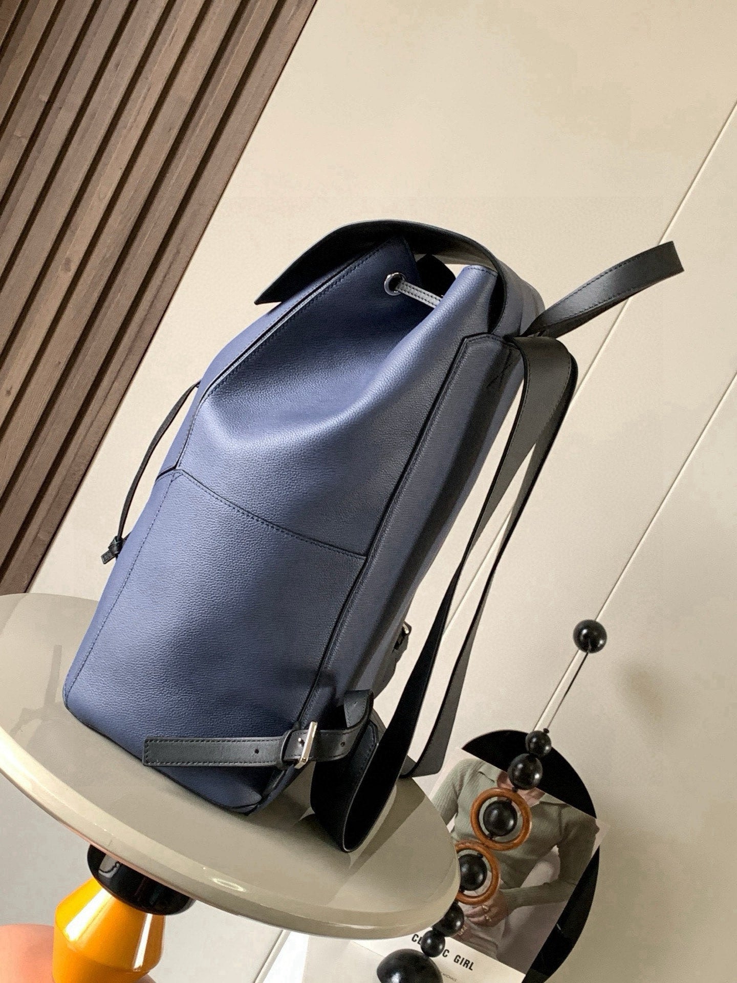 Blue leather backpack with curved top opening and adjustable shoulder straps