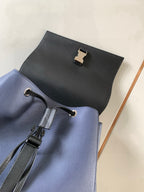 Blue leather backpack with front pull tabs and top flap hardware