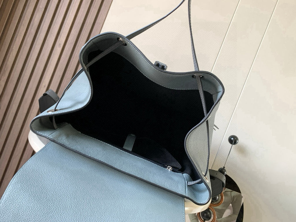 Loewe light blue leather backpack bag open showing black-lined interior pocket