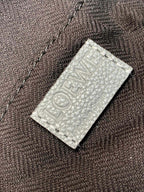 Loewe embossed leather label on light blue material backing