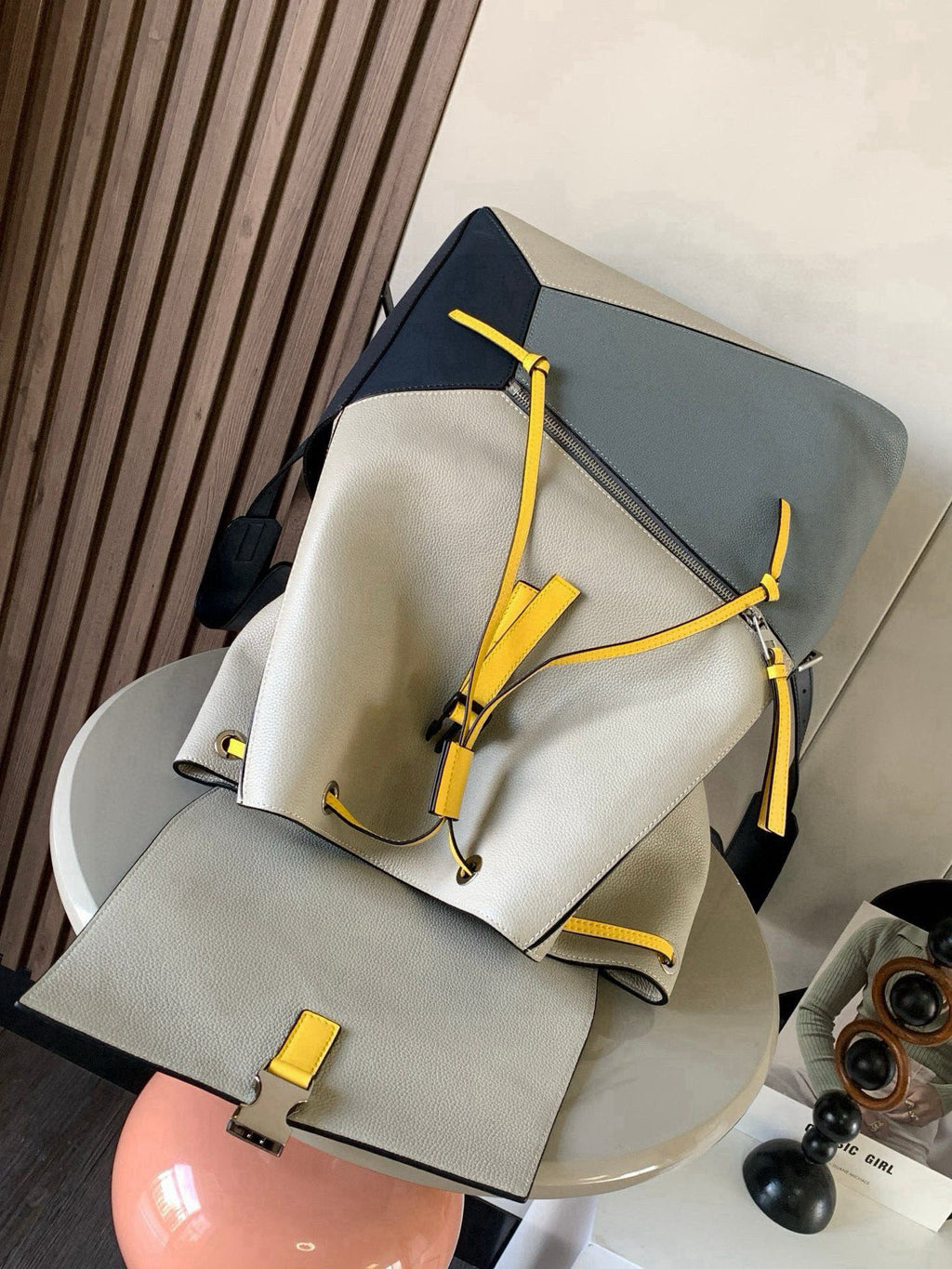 Loewe men's bag with cream body, blue trim and yellow cords, folded strap detail