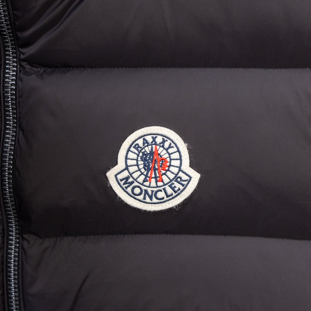 Moncler circular logo patch on black puffer vest fabric