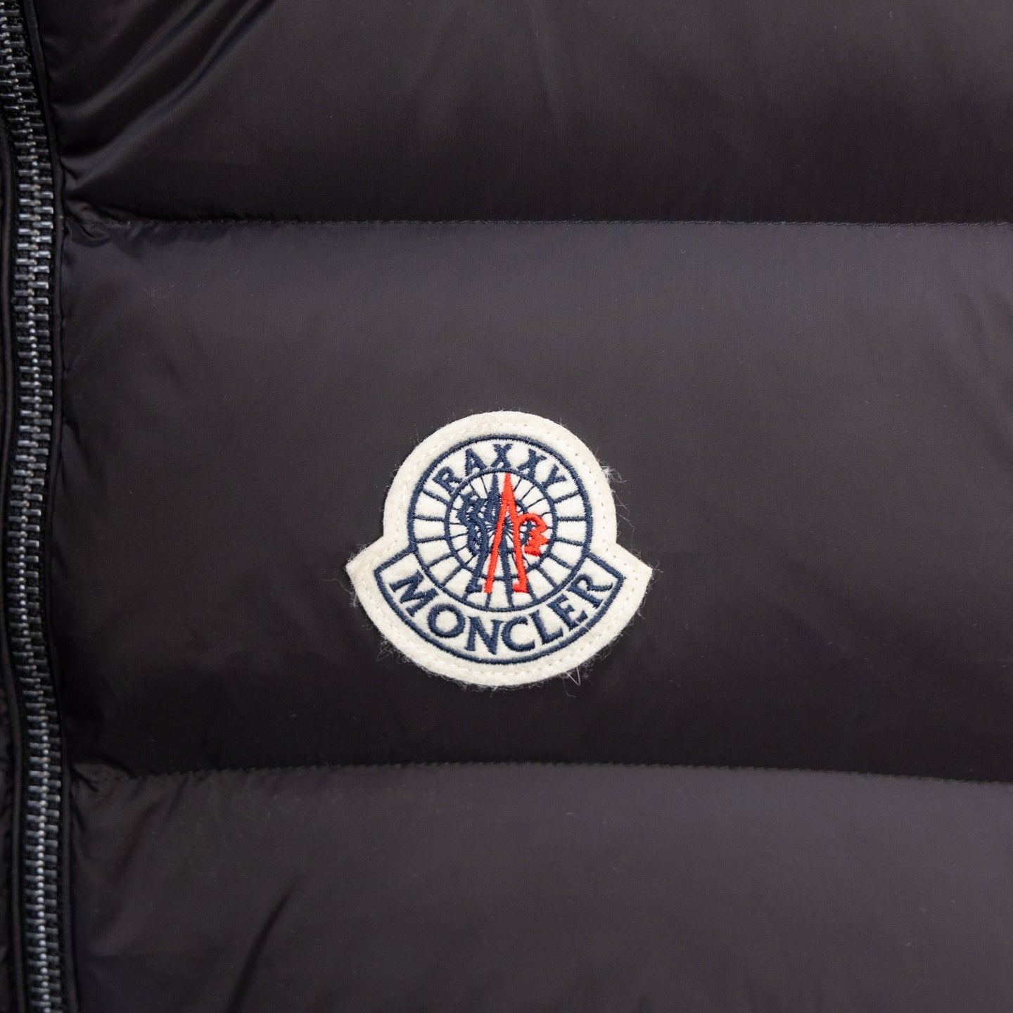 Moncler circular logo patch on black puffer vest fabric