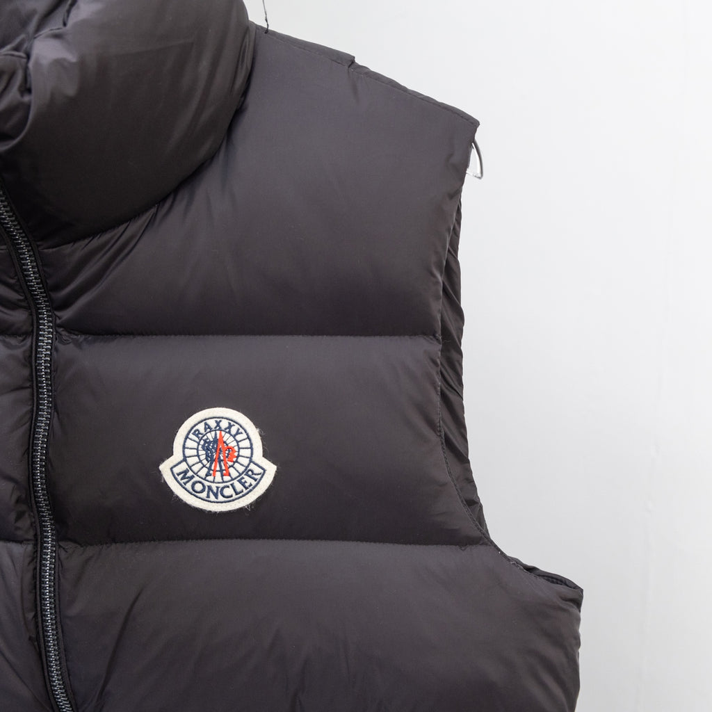 Moncler black puffer vest with circular logo patch on the chest