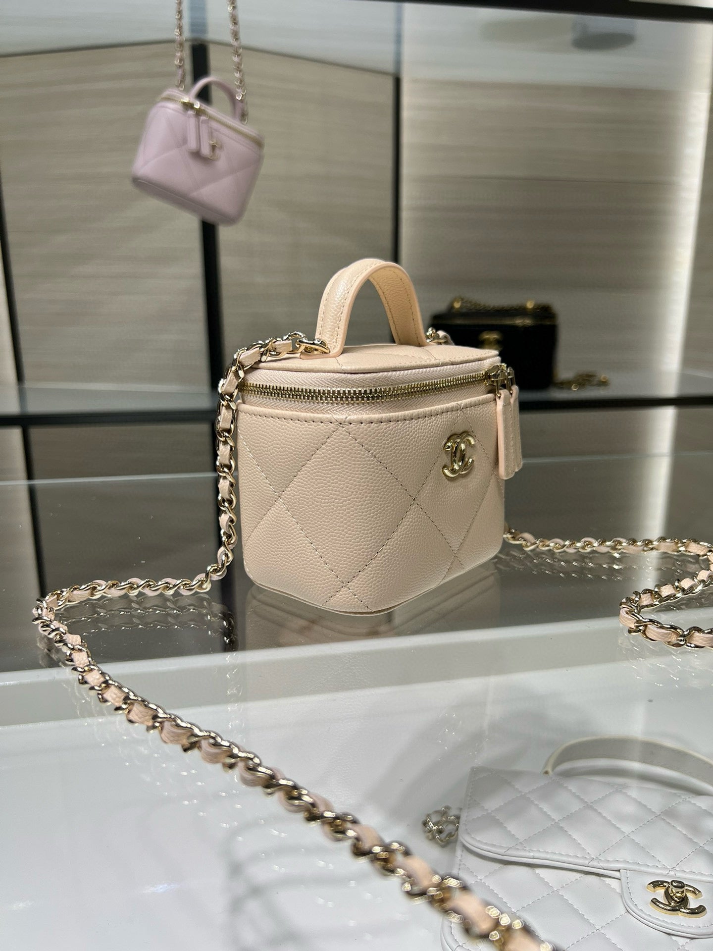 Small light beige quilted handbag with gold chain strap and top handle