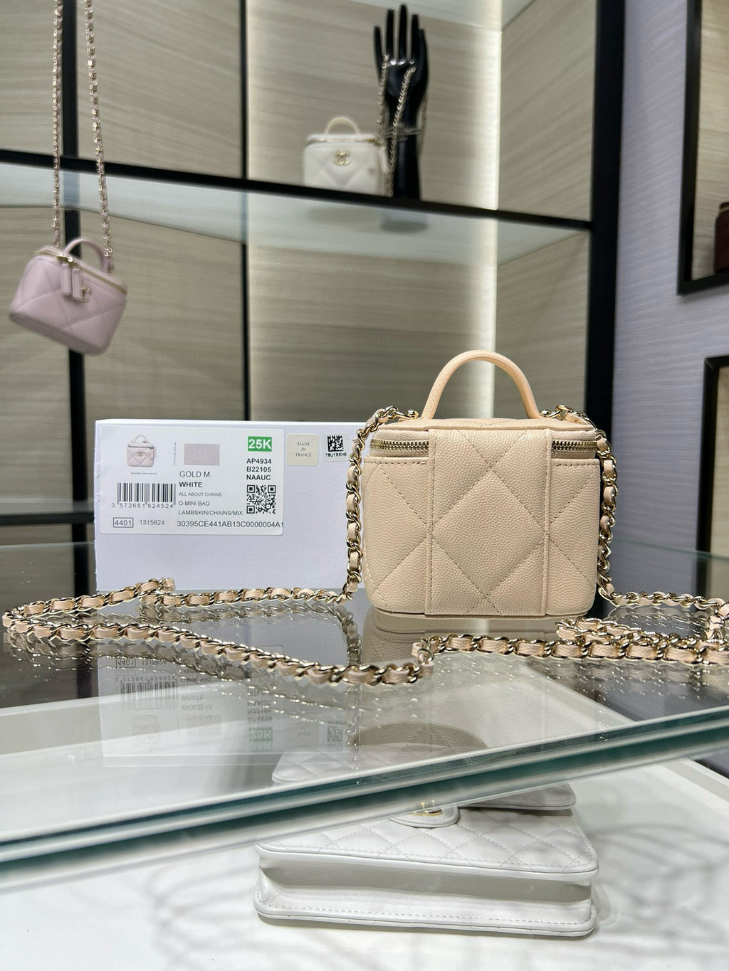 Small quilted beige handbag with gold-tone chain strap and top handle