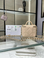 Small quilted beige handbag with gold-tone chain strap and top handle