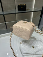 Beige quilted mini handbag with gold logo clasp and chain shoulder strap