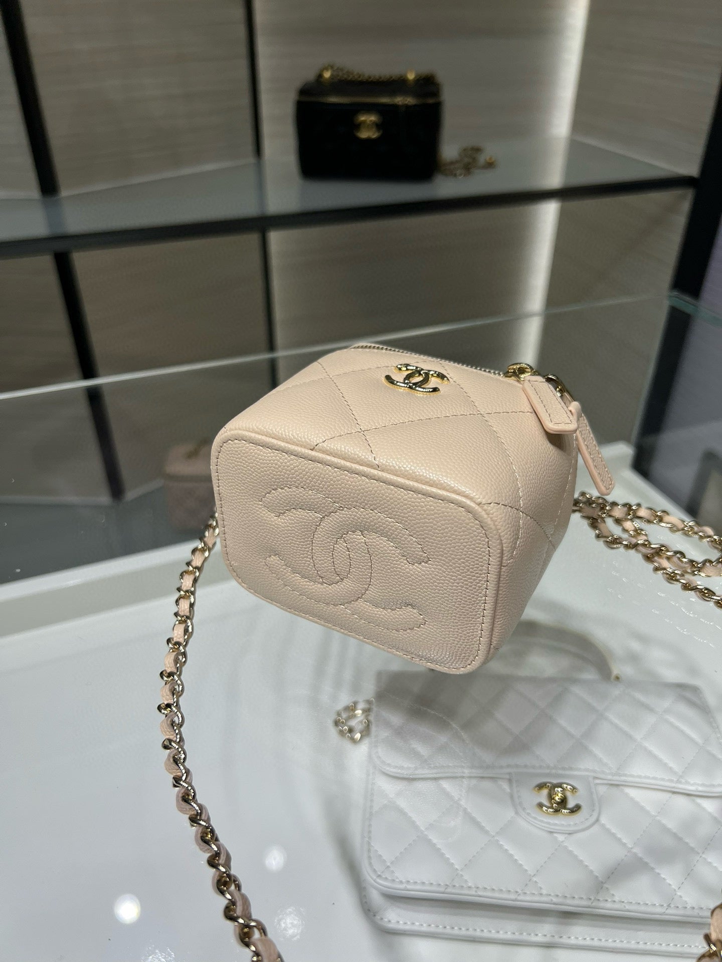 Beige quilted mini handbag with gold logo clasp and chain shoulder strap