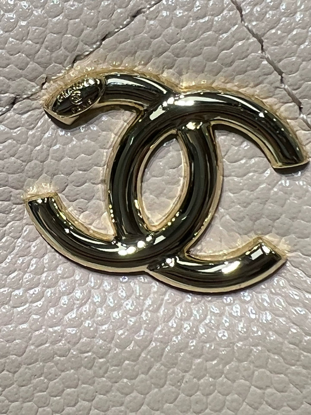 Gold-tone Chanel logo charm on textured light leather