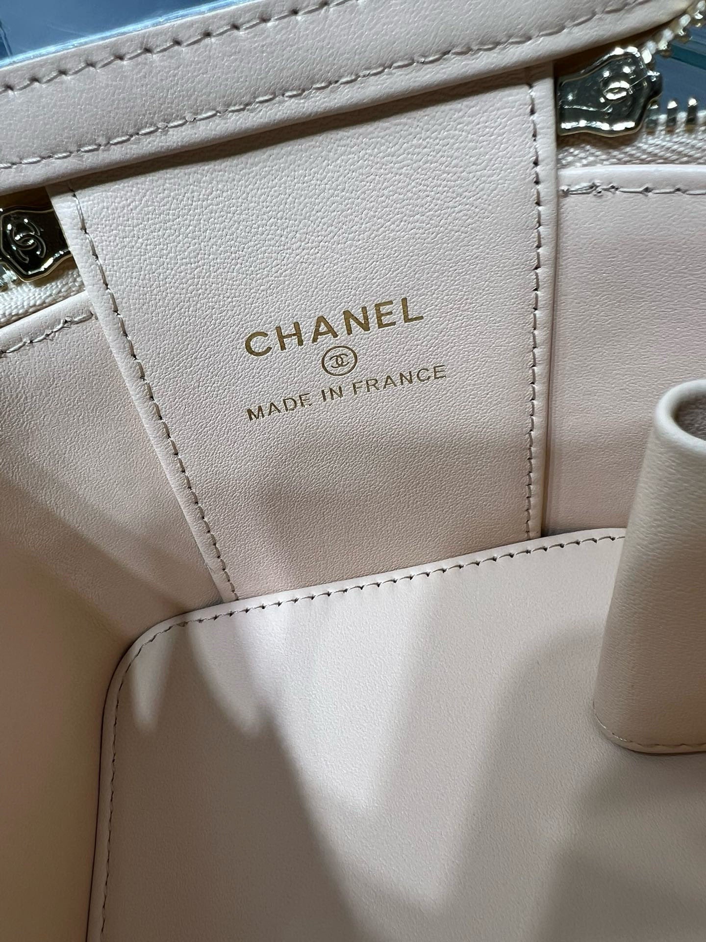 Light beige leather bag label reading CHANEL and MADE IN FRANCE
