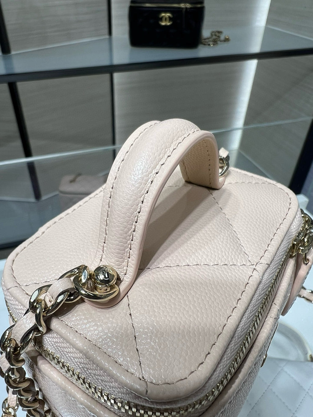 Light beige mini handbag with top handle and gold-tone chain strap hardware