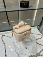 Light beige quilted mini handbag with zip top, chain strap, and gold hardware