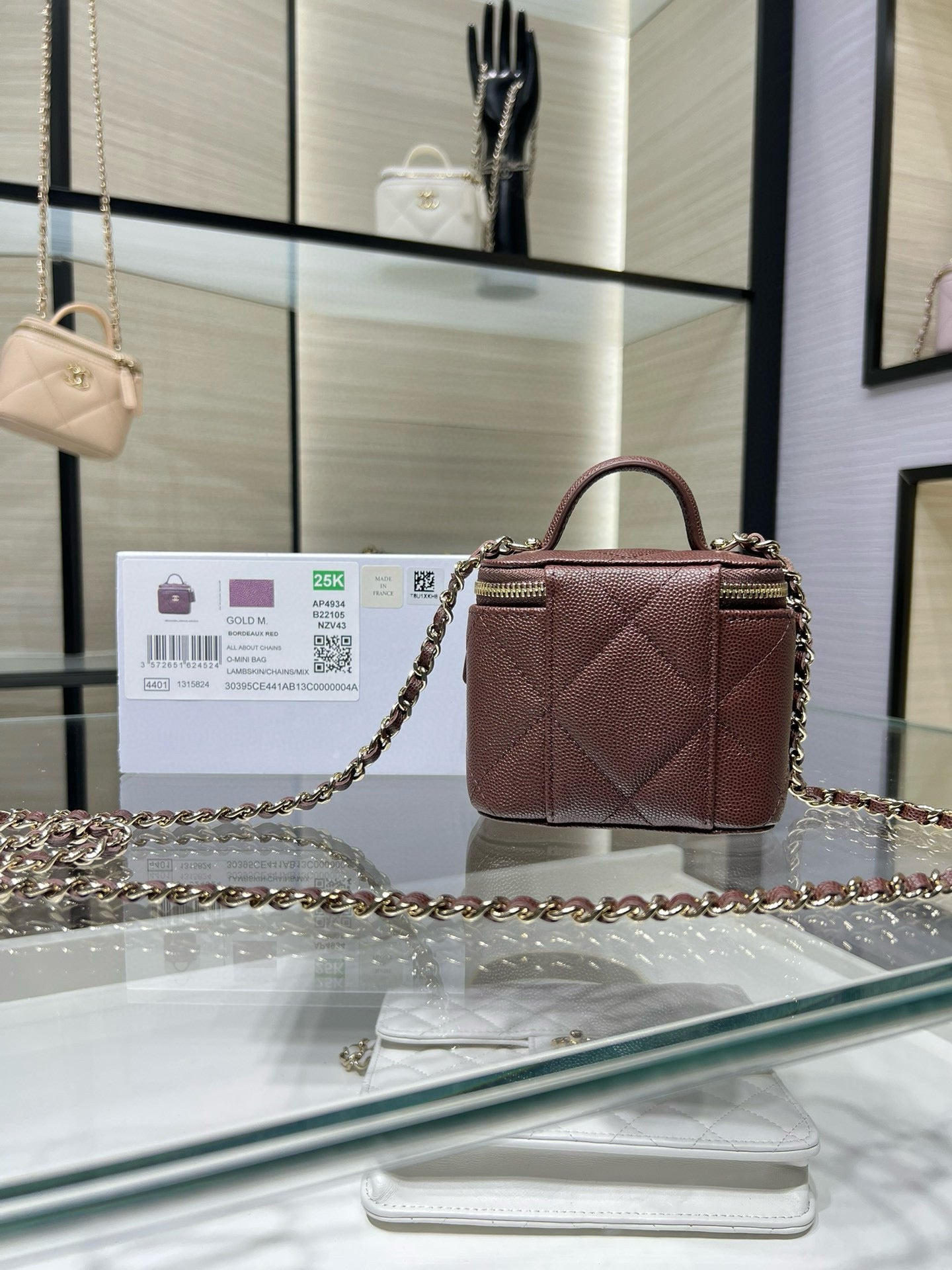Maroon mini handbag with diamond quilting, gold chain strap, and zipper
