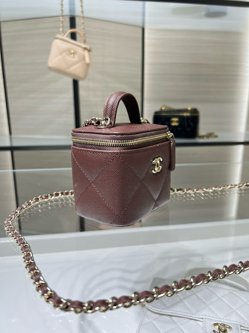 Maroon textured mini handbag with top handle and gold chain strap