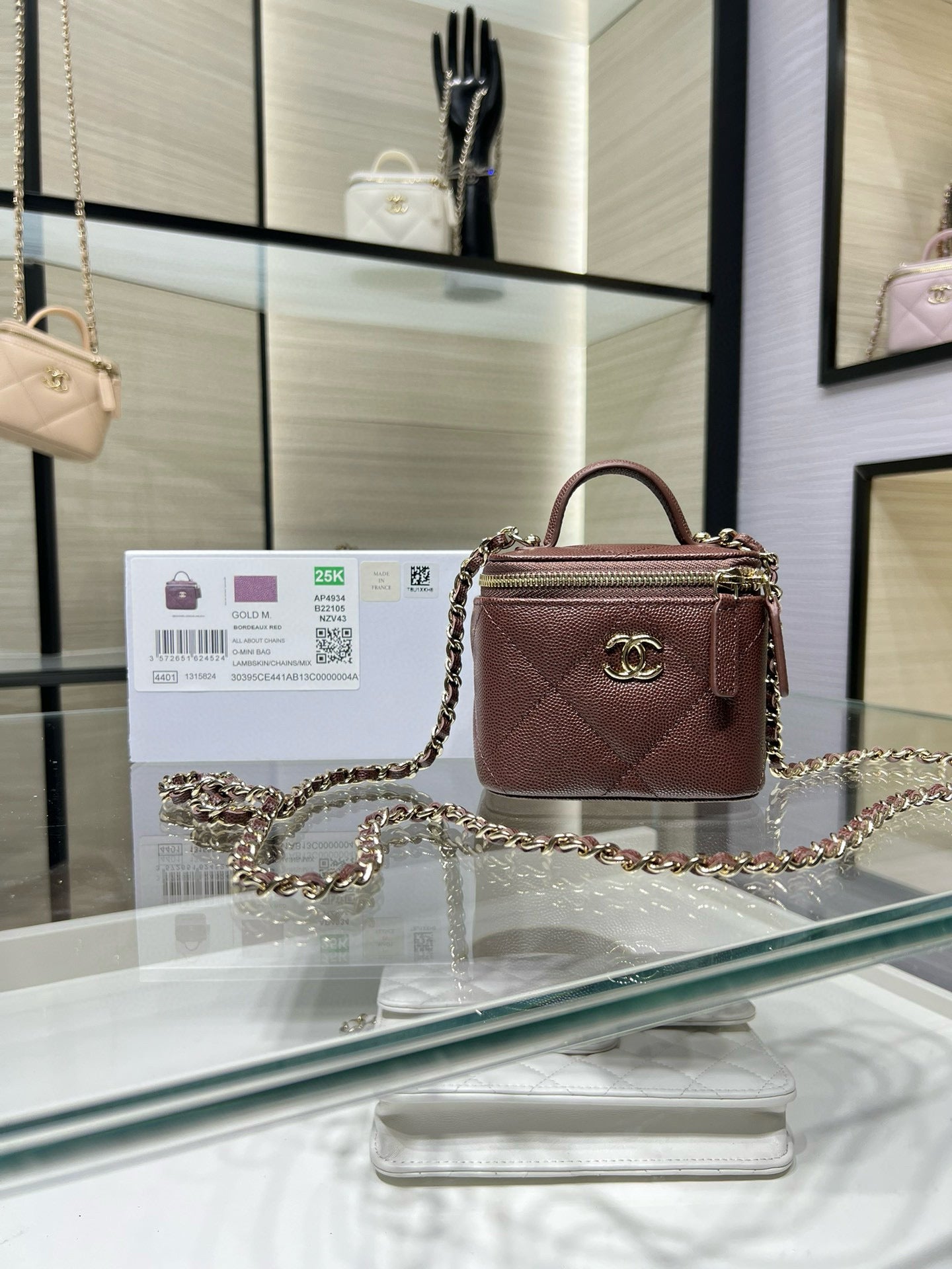 Maroon quilted mini handbag with gold chain strap and top handle