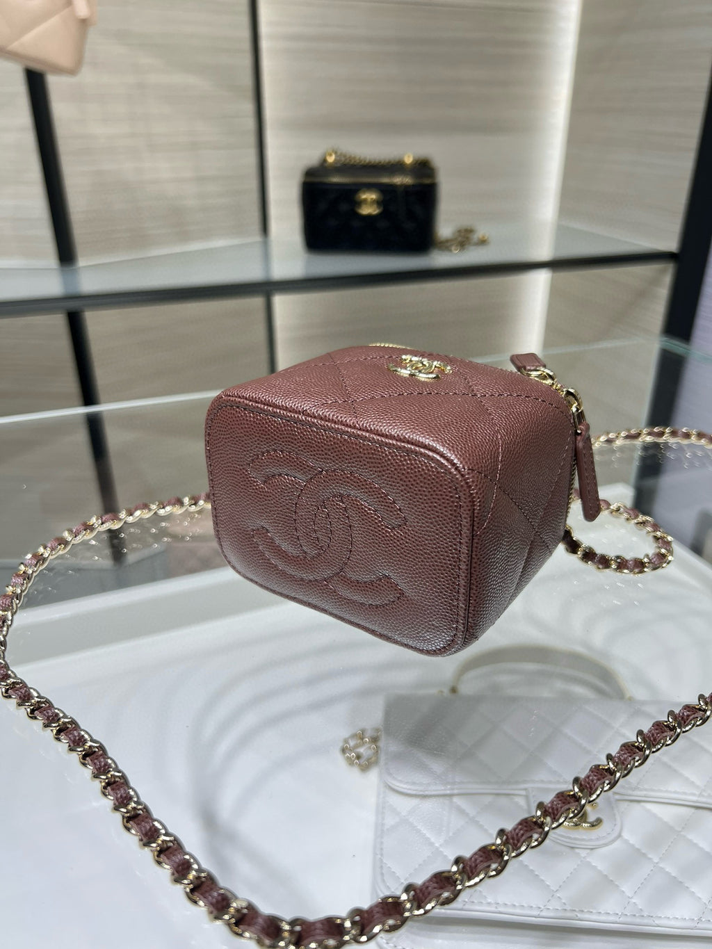 Maroon textured mini handbag with gold clasp and crossbody chain strap
