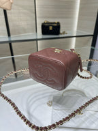 Maroon textured mini handbag with gold clasp and crossbody chain strap
