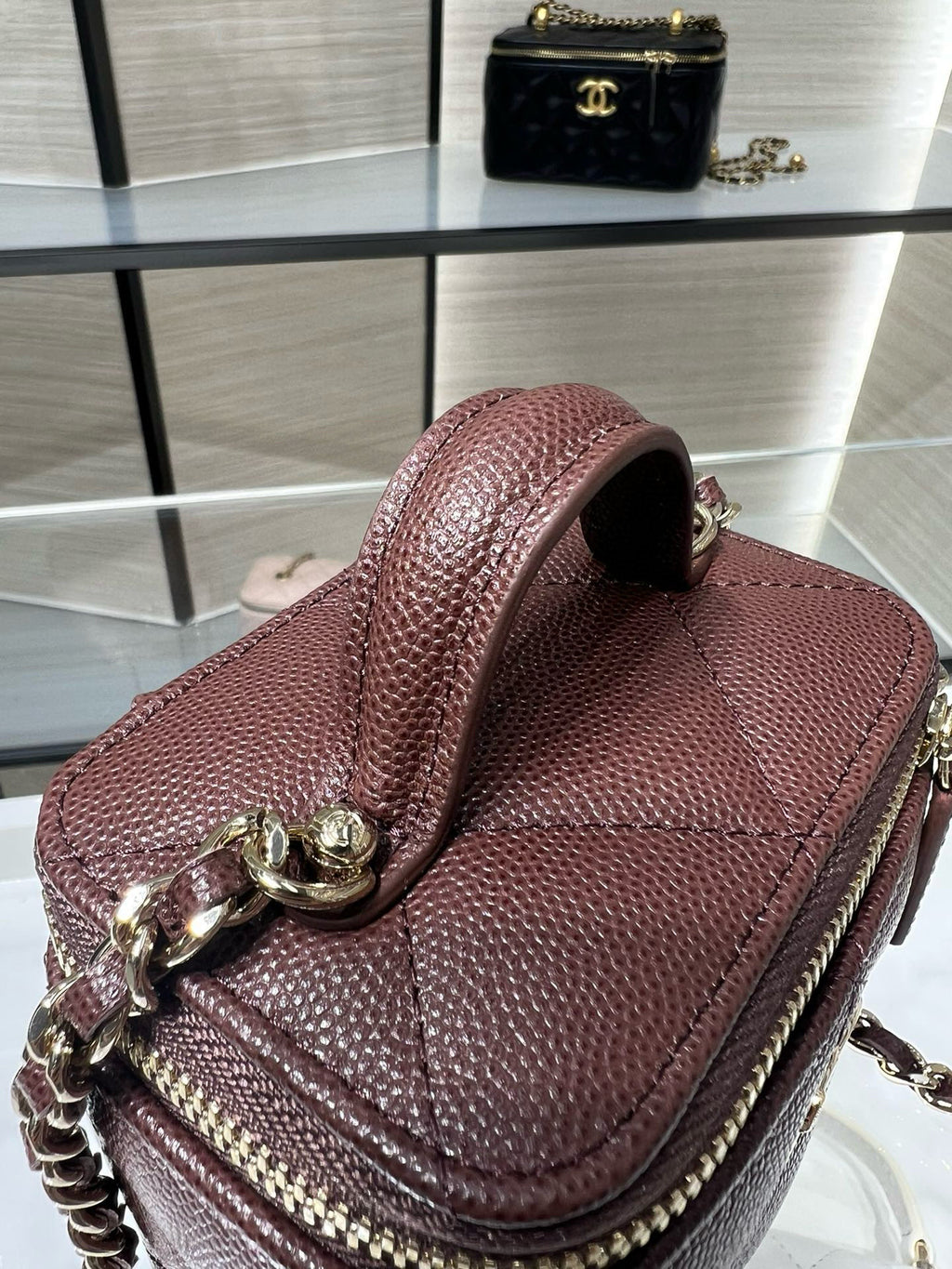 Maroon mini handbag with structured flap, gold chain strap, and CC charm