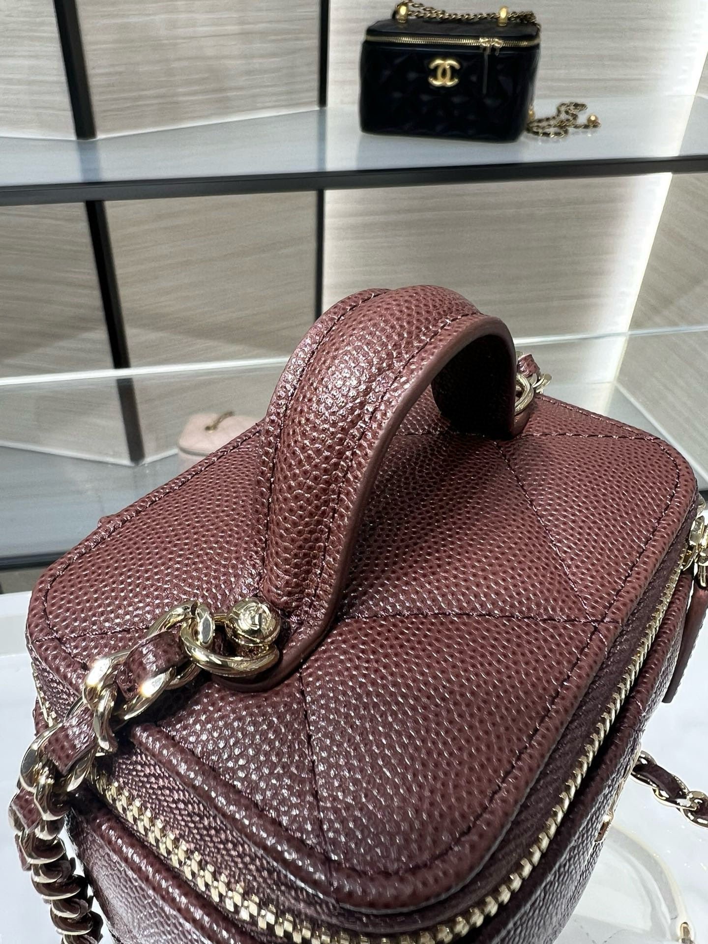 Maroon mini handbag with structured flap, gold chain strap, and CC charm