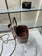 Maroon mini handbag with open top and gold zipper on display