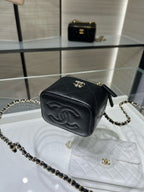 Black mini bag with gold zipper, CC emblem, and gold chain crossbody strap
