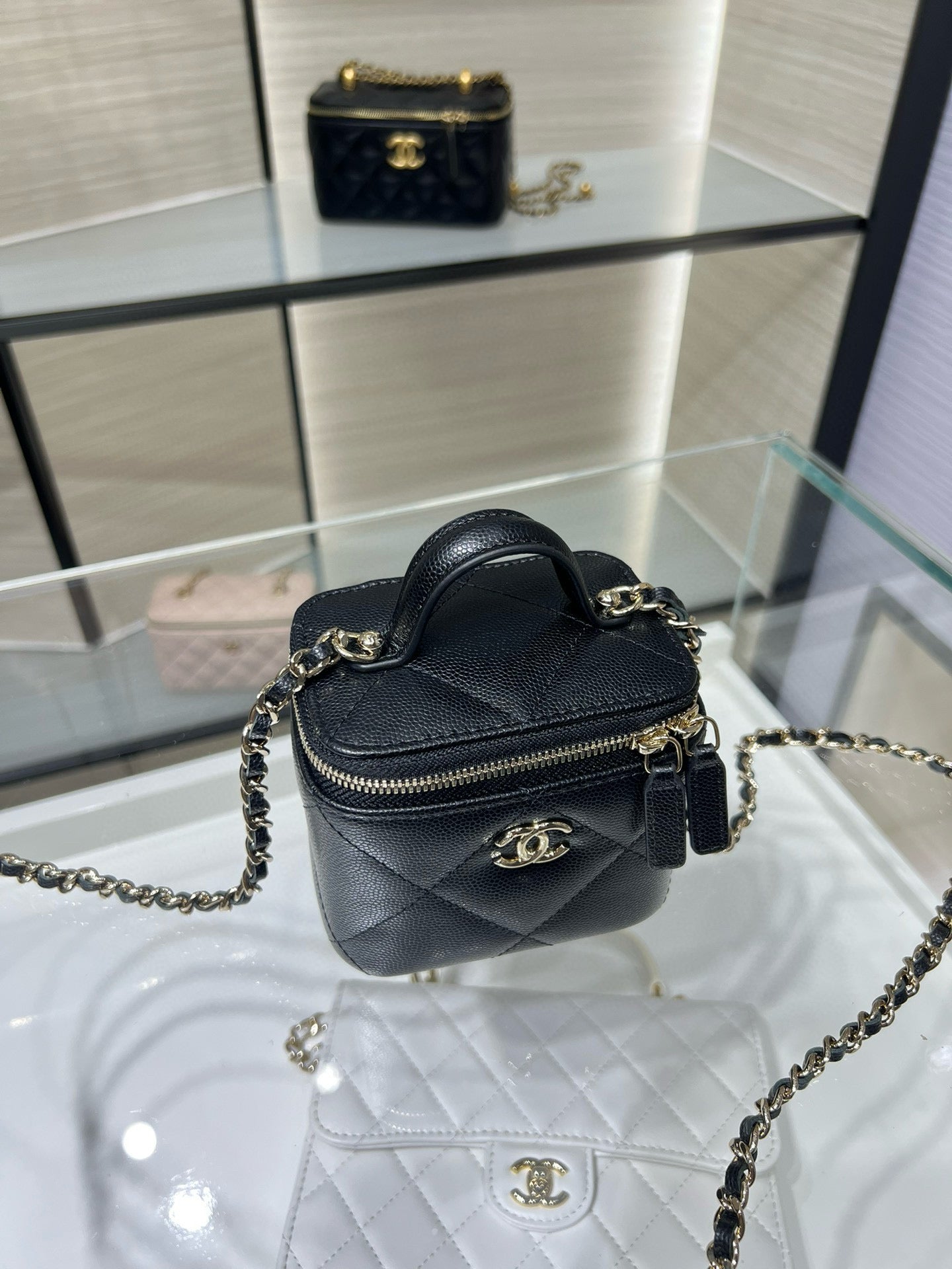 Black mini leather bag with gold chain strap, zipper top, CC emblem