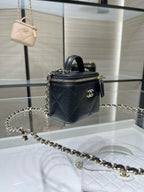 Black mini top-handle bag with gold chain strap and quilted texture, CC emblem