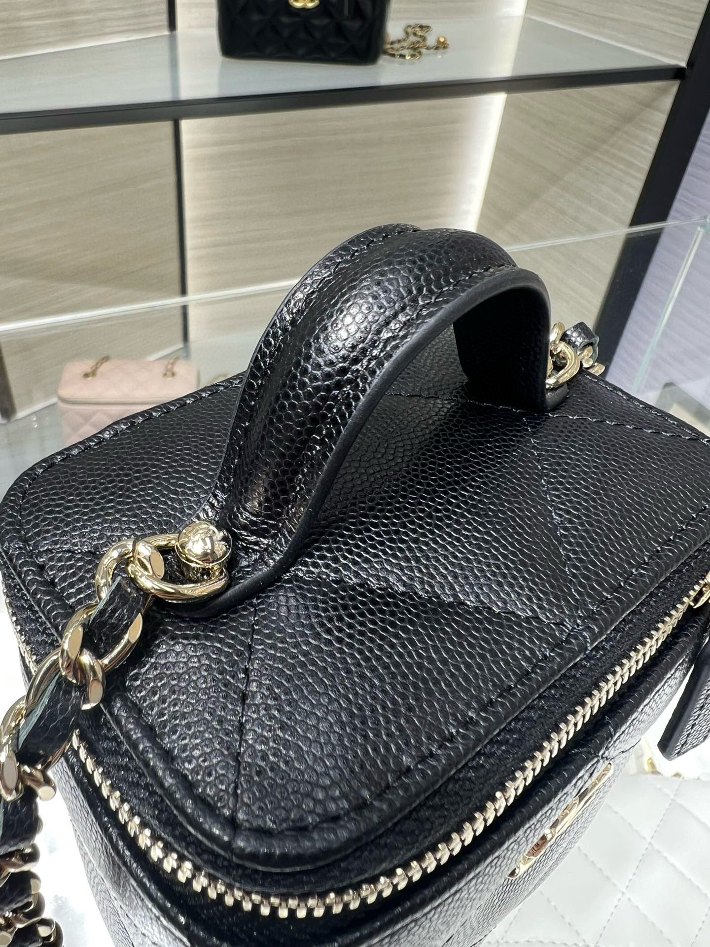 Black textured leather mini bag with gold chain strap and top handle, CC emblem