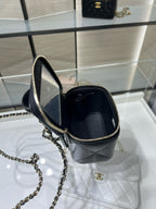 Black mini bag with gold chain strap; open top shows interior, CC emblem