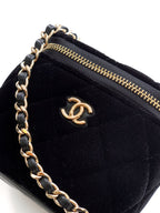 Black Chanel mini bag close-up with gold zipper and CC logo on front