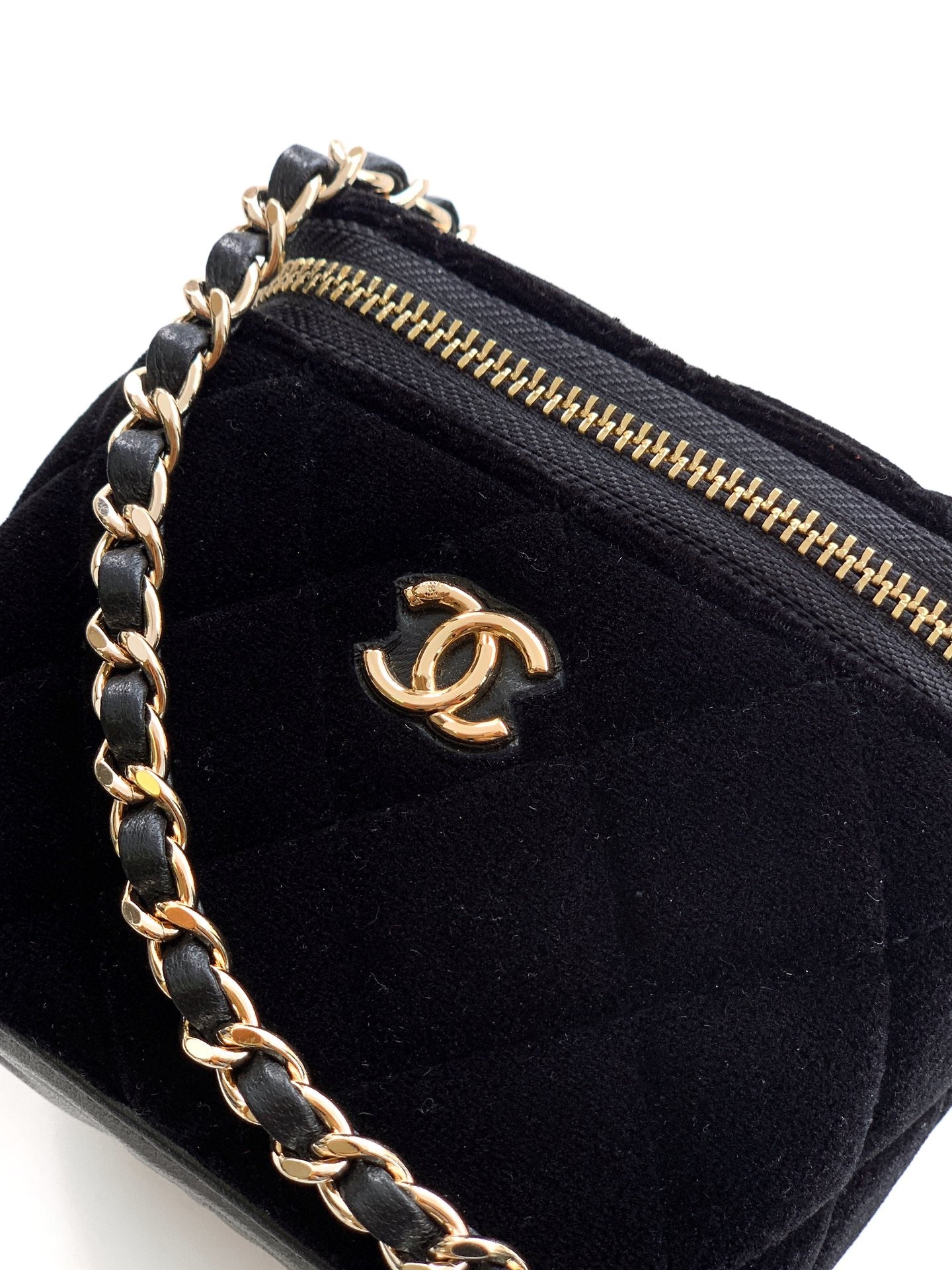 Black Chanel mini bag close-up with gold zipper and CC logo on front